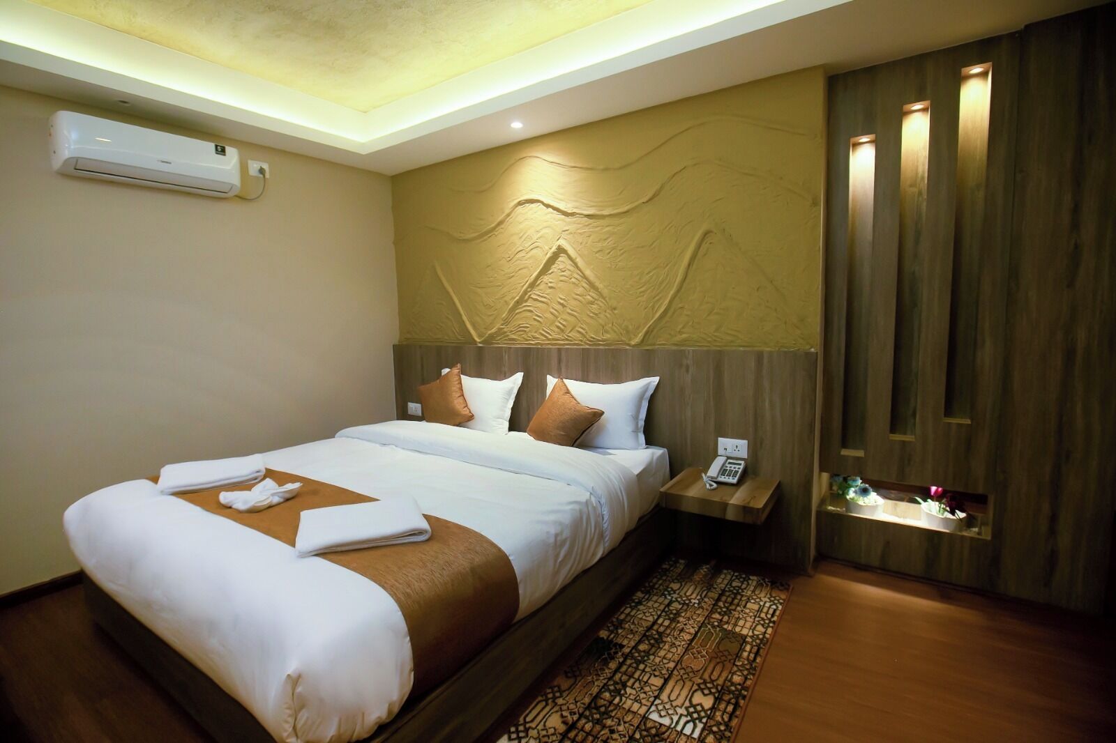 Une chambre d’hôtel équipée d’un lit, d’une table de chevet et d’un appareil de climatisation.