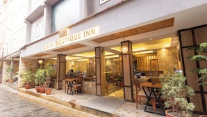 A boutique hotel with a stone facade, outdoor seating area with potted plants, and a visible entrance. - Divya Boutique Inn (Kathmandu)
