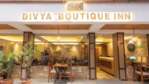 The exterior of Divya Boutique Inn with a stone facade, wooden furniture, and potted plants. - Divya Boutique Inn (Kathmandu)