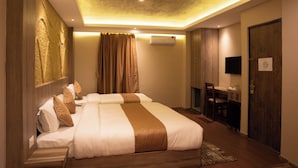 A hotel room with a large bed, a desk, and a chair. - Divya Boutique Inn (Kathmandu)