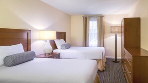 Two single beds with headboards and bedside tables, a flat-screen TV, and a wardrobe.