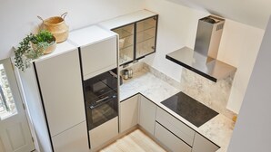 A modern kitchen with a built-in oven, a stainless steel range hood, and a marble countertop. - Host Stay Sunshine Cottage (Leyburn)