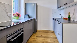 A modern kitchen with a built-in oven, a refrigerator, and a sink.