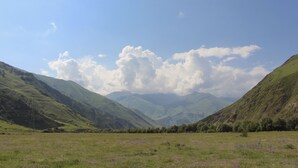A mountainous landscape with a valley and a clear sky. - Hotel TWINS Achkhoti (Kazbegi)