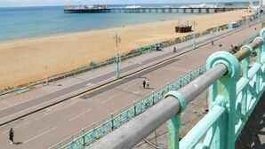 Une route côtière avec une plage et une jetée en arrière-plan.