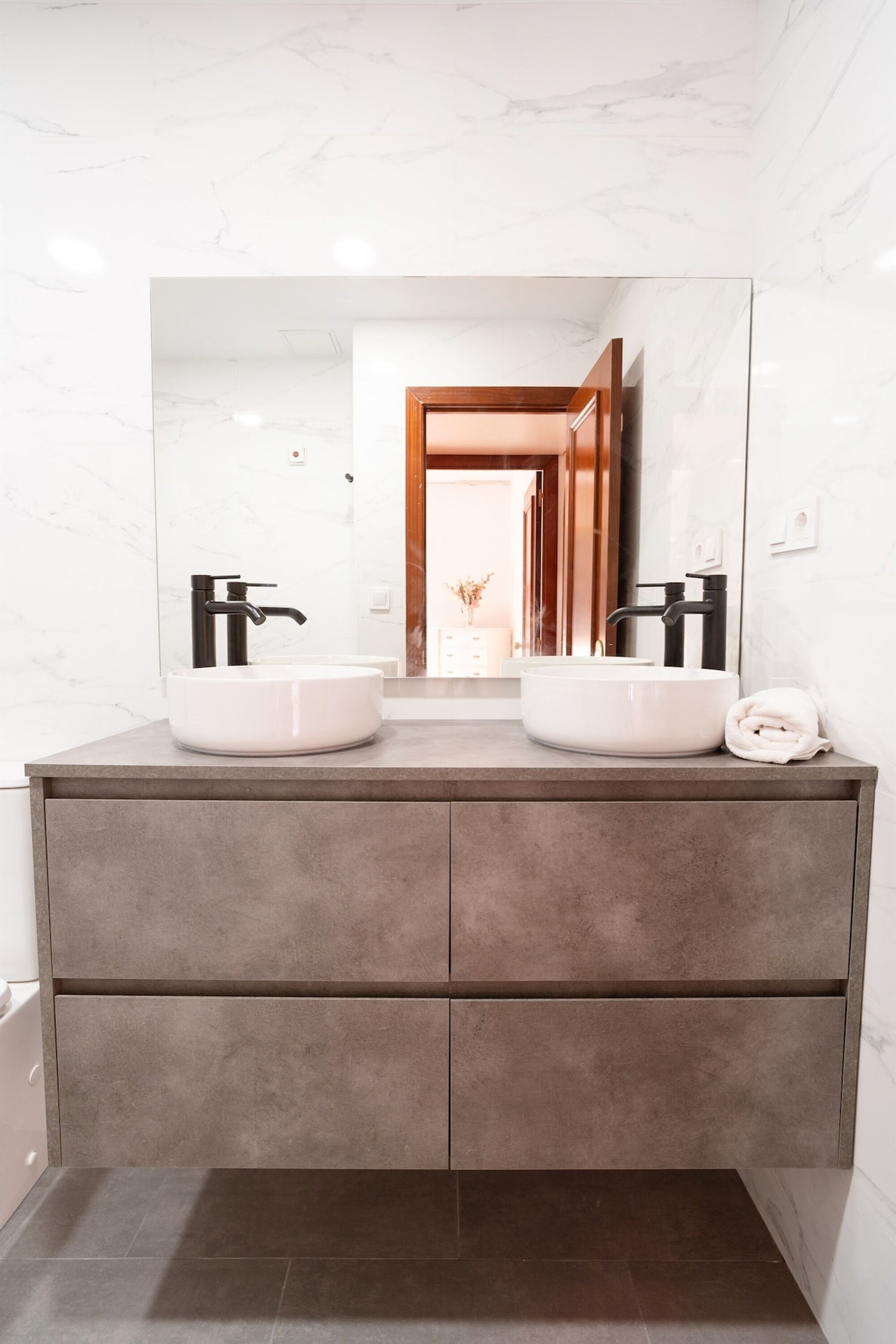 A bathroom with two sinks, a large mirror, and a towel on the counter.