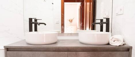 A bathroom with two sinks, a large mirror, and a towel on the counter.