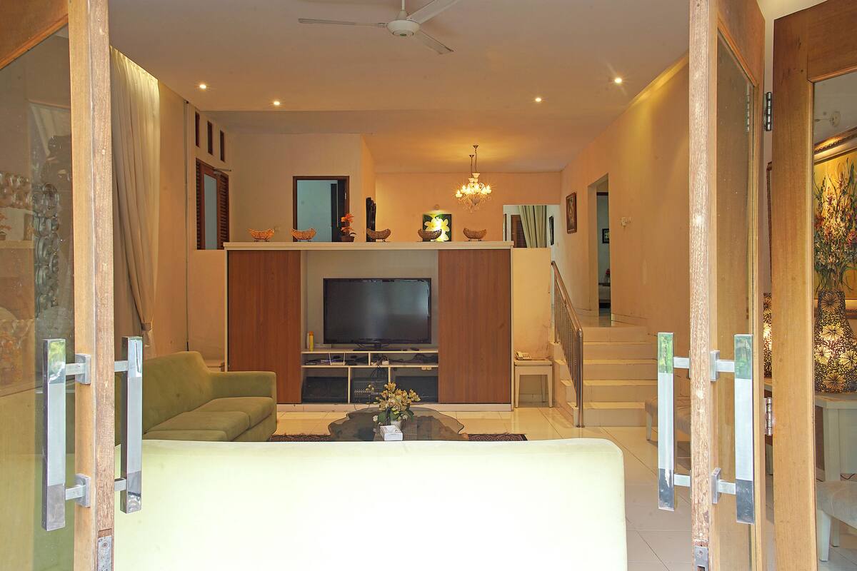 A living room with a television, sofa, and coffee table.