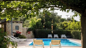 A swimming pool with lounge chairs, a stone building, and a hedge. - Villa Nefeli with Private Pool by Konnect (Corfu)