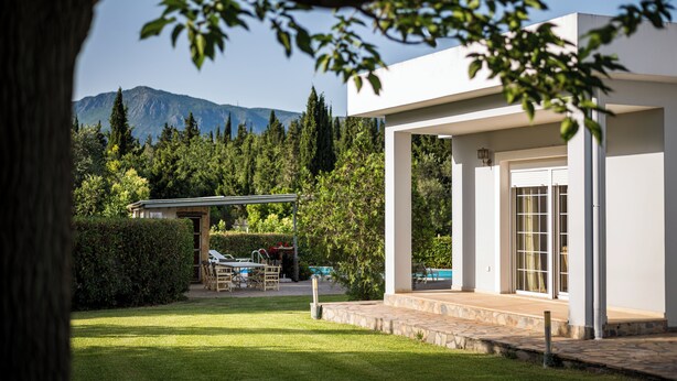 A modern house with a covered patio, a swimming pool, and a mountain backdrop. - Villa Nefeli with Private Pool by Konnect (Corfu)