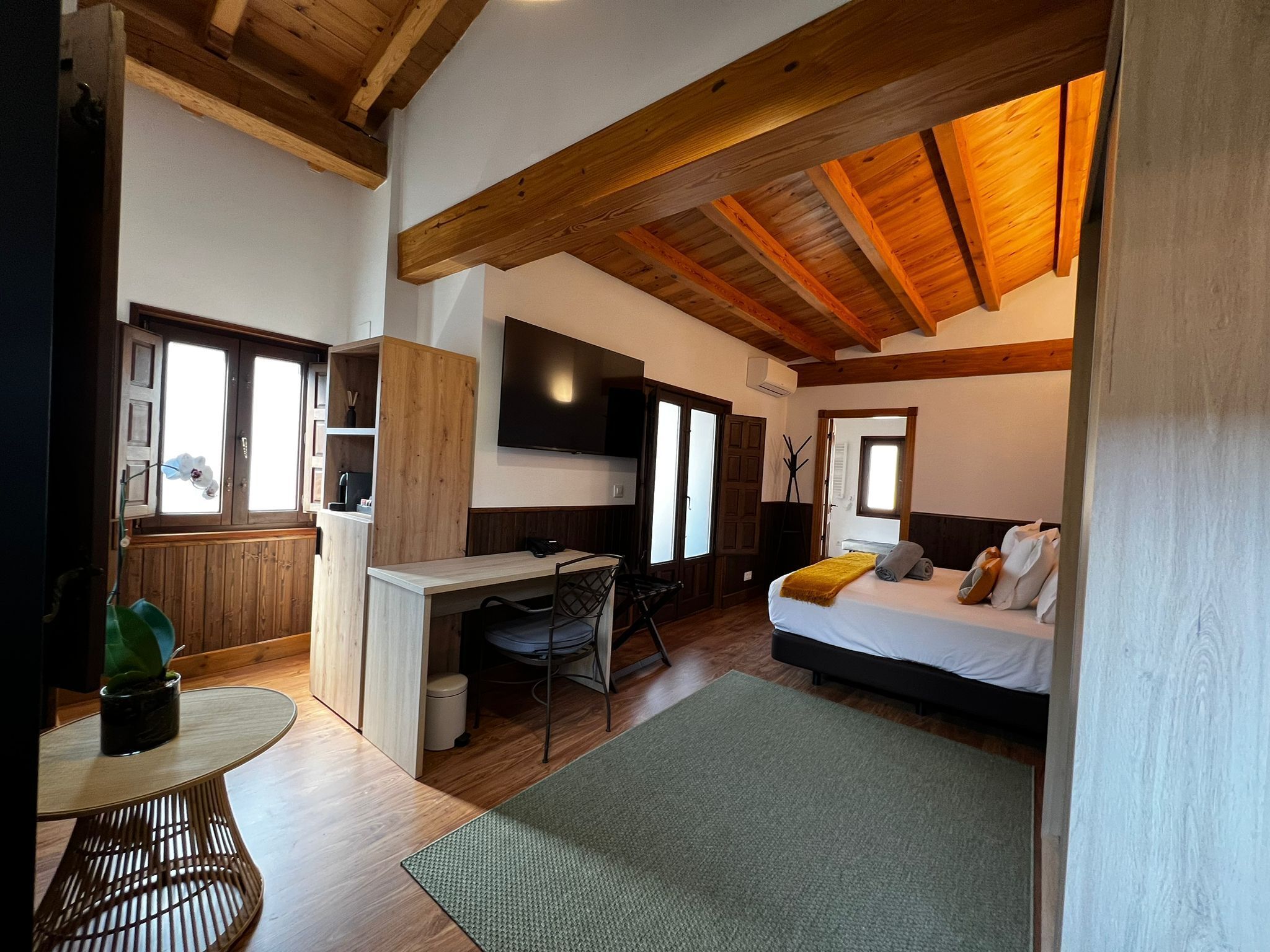 Una habitación pequeña y funcional con cama, mesita de noche y espacio para escritorio.