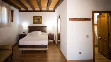 A bedroom with a wooden ceiling, a bed with white bedding, a nightstand, a bedside table, and a mirror.