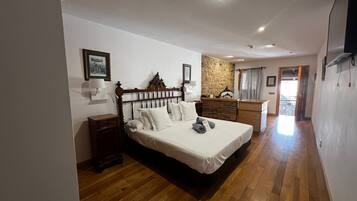A bedroom with a wooden bed, a dresser, a stone accent wall, and a view of the outside.