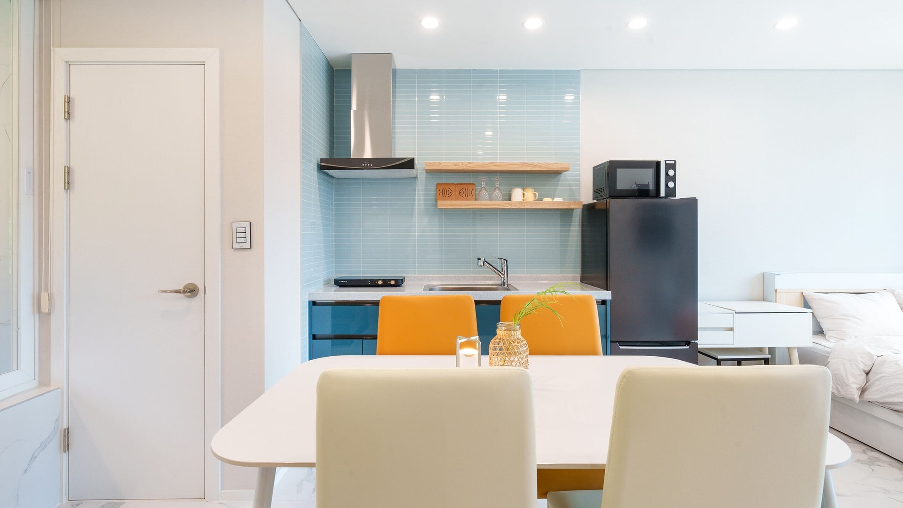 A modern kitchen with a dining area, a refrigerator, and a microwave.