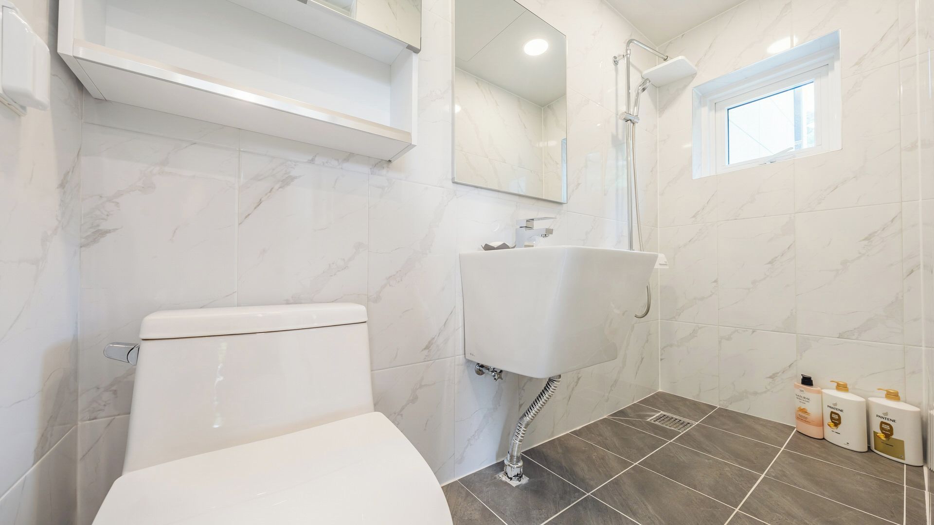 Un baño con inodoro, lavabo y ducha.