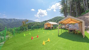 A campsite with two tents, a picnic table, and a grassy area with exercise cones. - Gapyeong Staysumok Pool Villa Pension (Gapyeong)