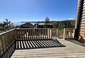 A wooden deck with a view of a lake and a mountain. - Lakefront House - BBQ; Views & near lake access (Puerto Varas)