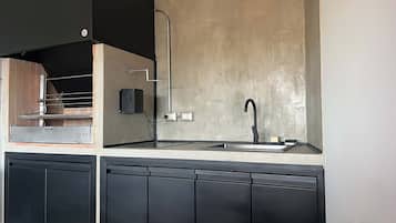 A modern kitchen with a built-in oven, a stainless steel sink, and black cabinetry.
