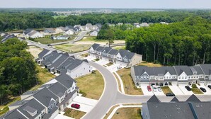 A residential area with multiple houses, a curved road, and a parking lot.