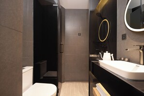 A modern bathroom with a glass shower enclosure, a white sink, and a mirror with a gold frame. - Captain 5 Youth Hotel Xinzhuang Branch (Shanghai)