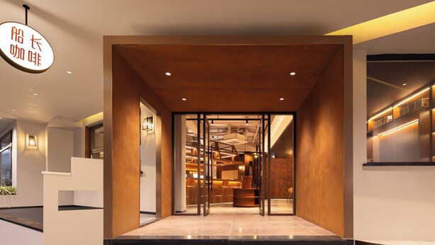 A modern hotel lobby with a reception desk, seating area, and a view into the interior. - Captain 5 Youth Hotel Xinzhuang Branch (Shanghai)