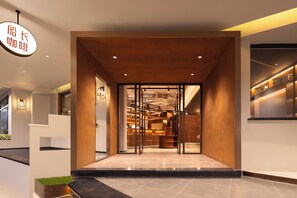A modern hotel lobby with a reception desk, seating area, and a view into the interior. - Captain 5 Youth Hotel Xinzhuang Branch (Shanghai)
