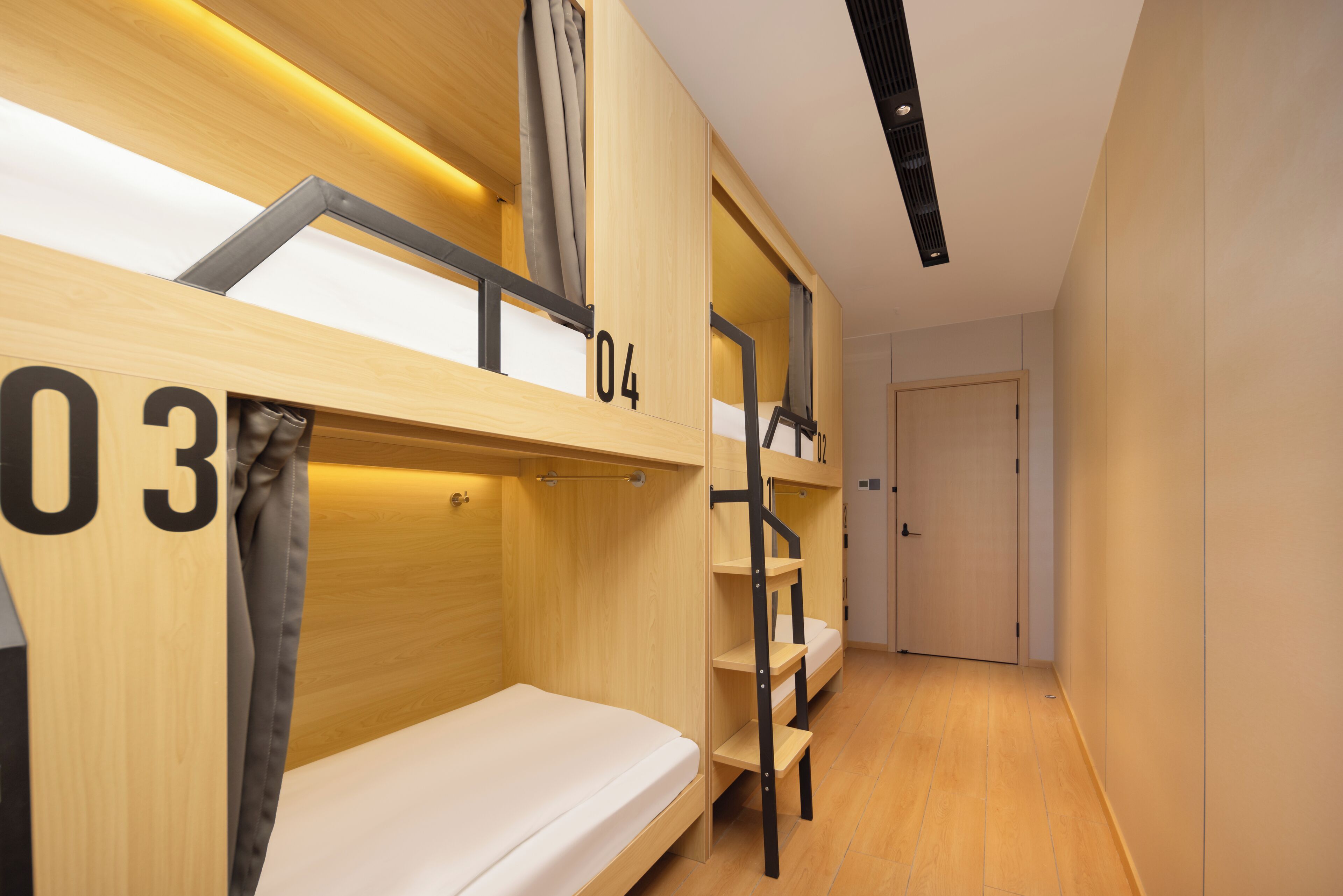 Une chambre avec un lit superposé, des murs en bois et une porte.