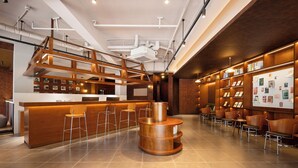 A modern hotel lobby with a wooden reception desk, bar seating, and a bulletin board. - Captain 5 Youth Hotel Xinzhuang Branch (Shanghai)