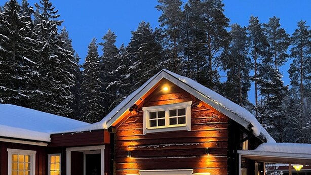 A log cabin with a snow-covered roof, a front porch, and a garage. - Charming Property With Private Pool (Marsta)