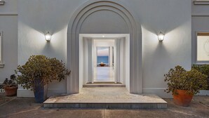 A grand entrance with a clear view to the sea, flanked by two large potted plants. - The Bay Crest Manor Views Pool Beach (Mount Eliza)