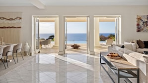 A spacious living room with a large open-plan layout, a dining area, and a view of the ocean. - The Bay Crest Manor Views Pool Beach (Mount Eliza)