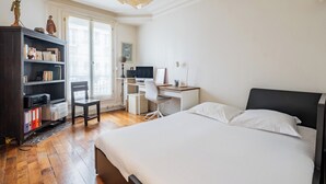 A bedroom with a bed, desk, chair, and a bookshelf. - Boho on the Boulevard, by Veeve (Paris)