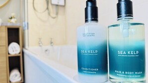 Two bottles of Sea Kelp conditioner and hair & body wash on a bathroom counter. - Top Floor Getaway With Cozy Canopy Bed (Edinburgh)