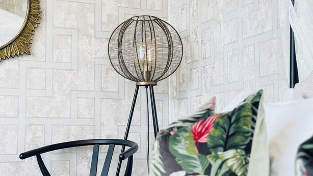 A bedroom with a bed, a chair, a floor lamp, a mirror, and a patterned wall. - Top Floor Getaway With Cozy Canopy Bed (Edinburgh)