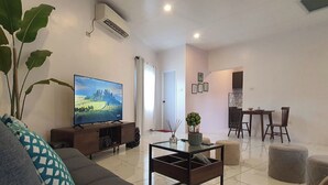 Un salon moderne comprenant un canapé, une table basse, un téléviseur et un coin repas.