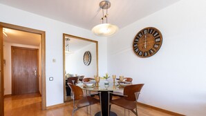 A dining area with a round table, chairs, and a wall clock. - Stunning views, 2-bedroom apartment, Salou centre UHC SANTILLANA 239 (Salou)