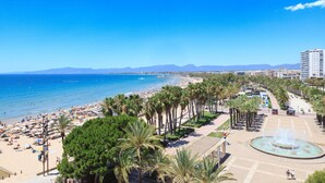 A beachside promenade with palm trees, a fountain, and a view of the sea. - Stunning views, 2-bedroom apartment, Salou centre UHC SANTILLANA 239 (Salou)