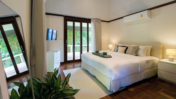 Un dormitorio con cama, mesita de noche y ventana.