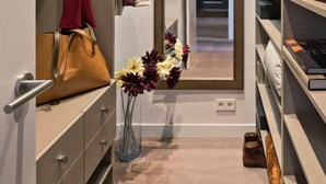 A modern walk-in closet with open shelving, a mirror, and a hanging rack. - Pau Claris Design Apt. Next to Paseo de Gracia (Barcelona)