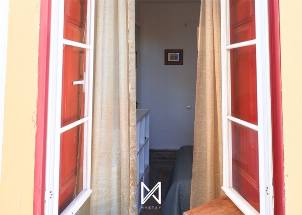 A doorway leading to a room with a bed and a small table. - MyStay - A Casa do Visconde (Mertola)