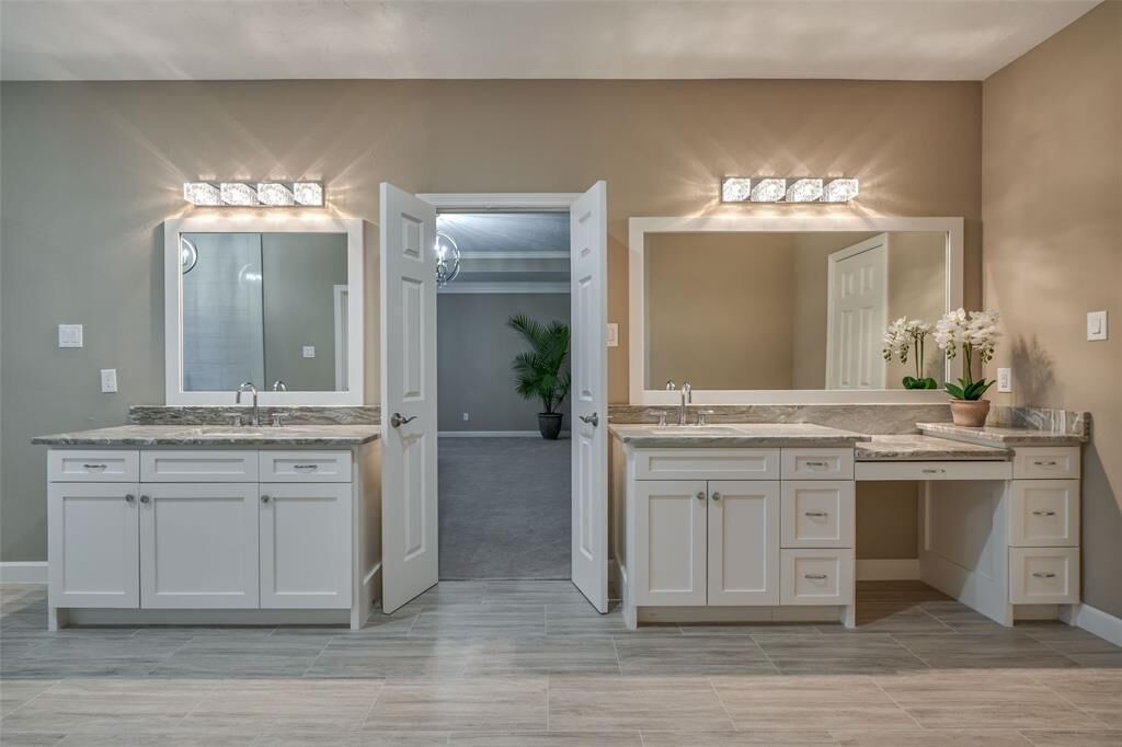 Un baño moderno con dos lavamanos, un espejo grande y una ducha a pie.