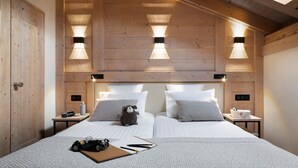 A bedroom with a wooden ceiling, two beds with white bedding, a stuffed animal on one bed, and bedside tables with lamps. - MGM Hôtels & Résidences – Résidence Akoya (Les Avanchers-Valmorel)