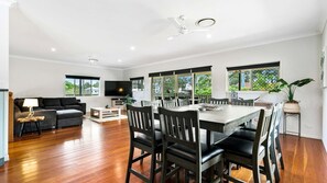 Relax in this stylish living area with a large dining table, comfortable sofa, and flat-screen TV.