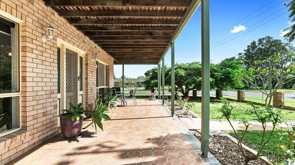 Relax in this serene outdoor space surrounded by lush greenery and a brick building with large windows.