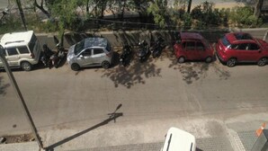 A parking lot with several cars and a white van. - Room-home Stay Bed And Break Fast (New Delhi)