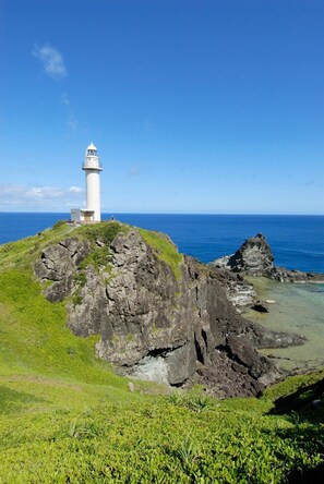 A lighthouse on a rocky outcrop with a clear view of the ocean. - Another Sky Ishigaki Island (Ishigaki)