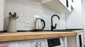 A kitchen with a coffee maker, kettle, and a pitcher on the counter. - Charming one-bedroom apartment in Madrid, close to the Tetuán metro (Madrid)