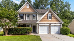 A two-story house with a front garage, a covered porch, and a landscaped front yard. - 5-Bed Gem Close to Duluth Fun-Sleeps 16 (Duluth)
