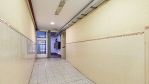 Un pasillo con pisos y paredes de baldosas, que conduce a una puerta al final.