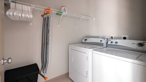 A laundry area with a washing machine, dryer, and drying rack. - Luxury Downtown Apartment (Columbus)